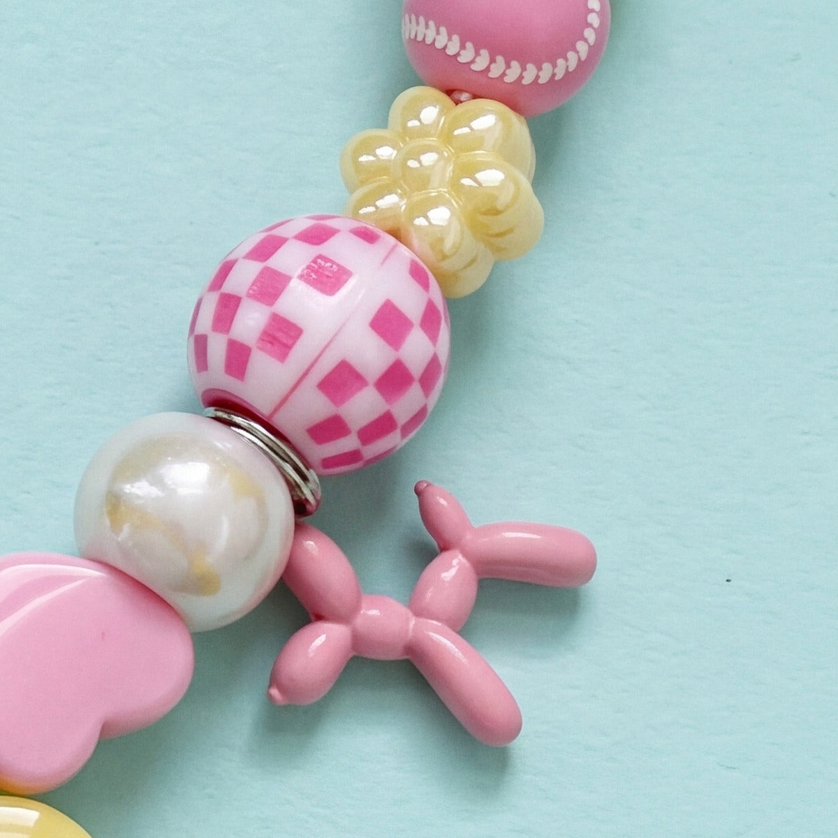 BEADBOO Blush Balloon Dog charm hanging on a handmade beaded dog collar [crop:charm-balloon-dog-blush__noori]