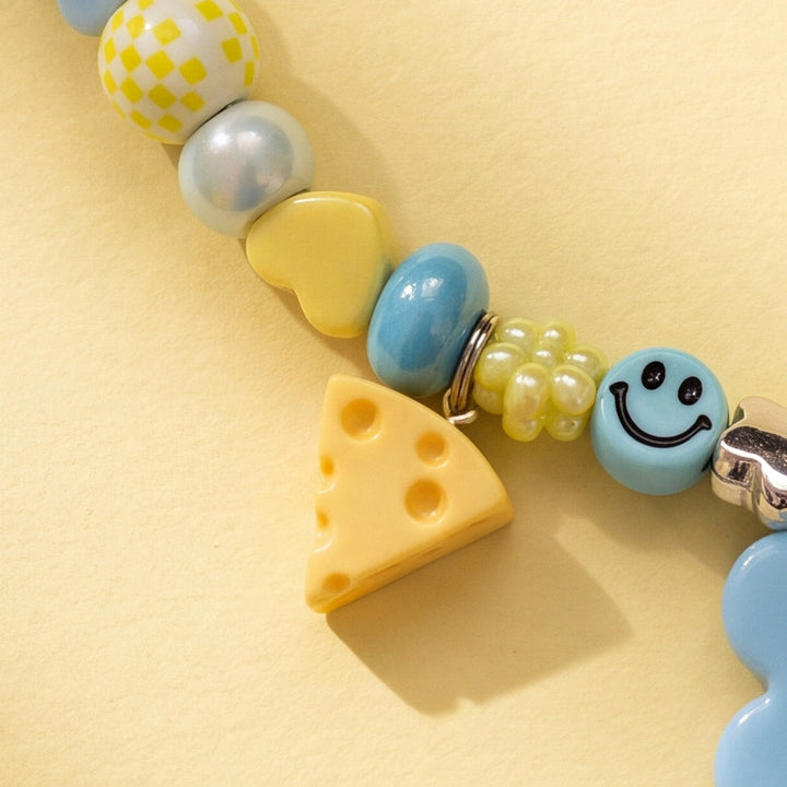 BEADBOO Swiss Cheese charm hanging on a handmade beaded dog collar [crop:charm-cheese__dollar]