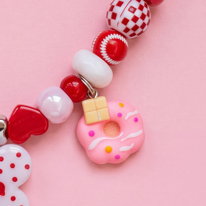 BEADBOO Sprinkle Donut charm hanging on a handmade beaded dog collar [crop:charm-donut__perla]